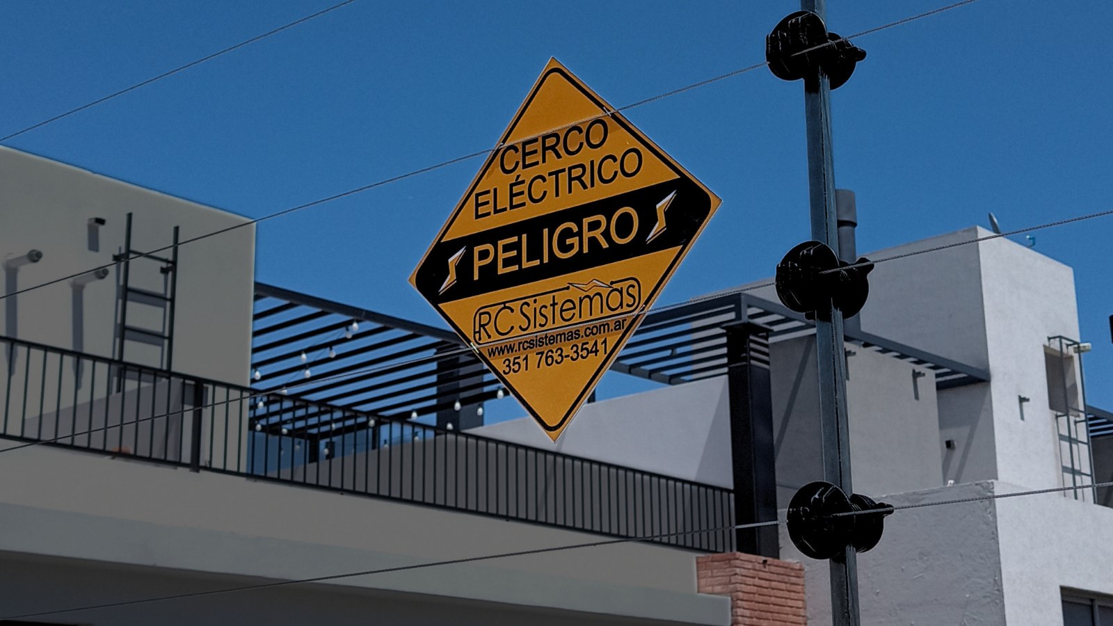 Cartel de cerco eléctrico de RC Sistemas sobre la terraza de una vivienda