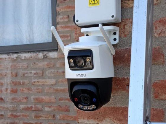 Cámara IP Wi-Fi Imou motorizada instalada sobre la pared de ladrillo de una vivienda