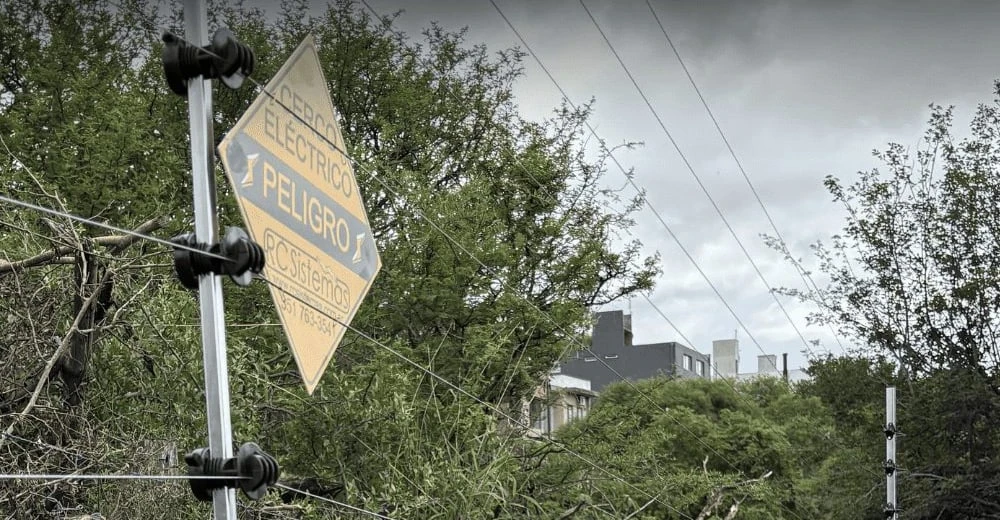Cartel reglamentario de peligro sobre un cerco eléctrico instalado por RC Sistemas